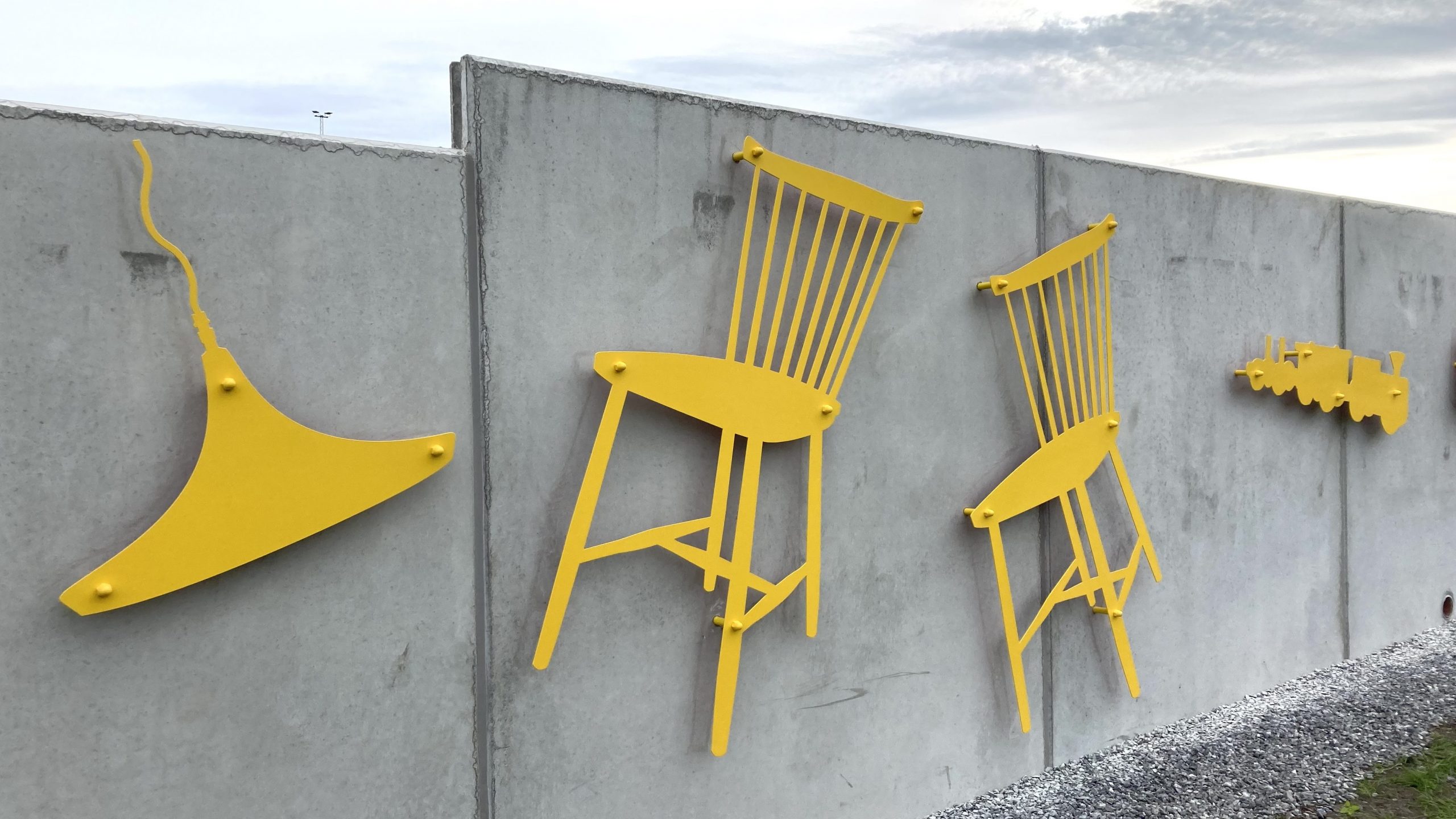 Bild på konstverket Huller om buller. Konstverket består bland annat av gula former av en stol och en lampa.