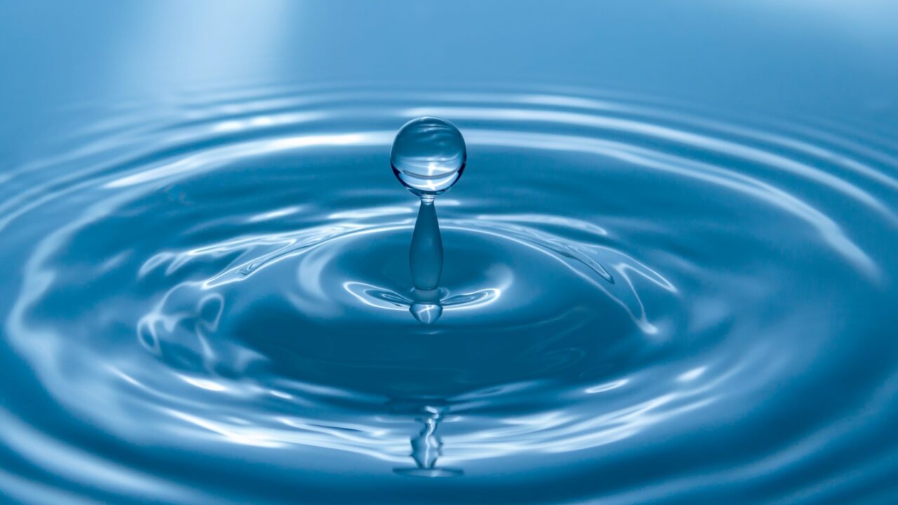 Bild av vatten i blå toner med droppe